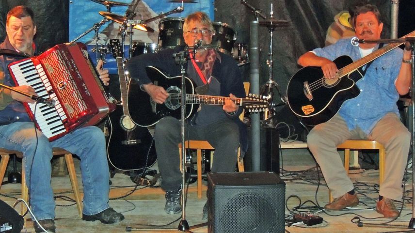 Paulin Nuotclà (d’immez) cun amis han pisserà per tuns loms al concert i’l liber a Sclamischot (fotografia: Benedict Stecher).