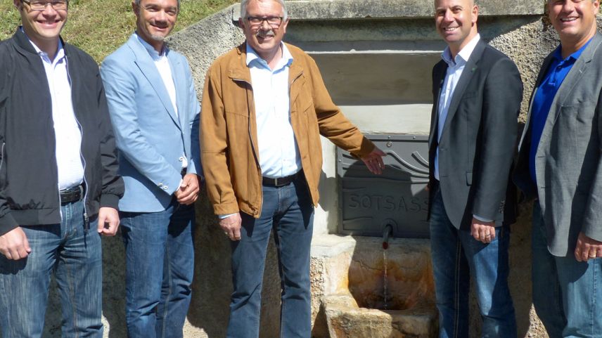 Ils partenaris dal Center da sandà Engiadina Bassa Gerhard Hauser, Richard Ploner, Christian Fanzun, Reto Flury e Joachim Koppenberg pro l’inauguraziun dal bügl renovà da la funtana Sotsass (fotografia: Flurin Andry).
