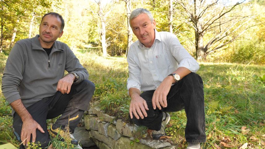 Förster Andrea Giovanoli (links) und Andrès Fasciati vom ewz Bergell an einem Entwässerungskanal in Brentan 