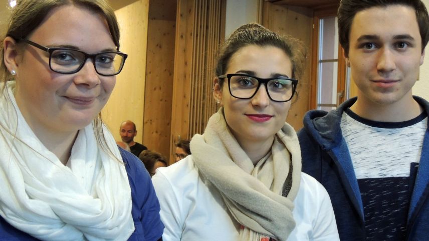 Ladina Clavadetscher, Marcia Ramos e Duri à Porta (da schnestra) han preschantà lur lavur (fotografia: Benedict Stecher).