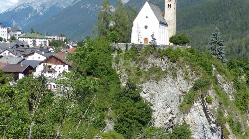 La baselgia San Geer es situada sül grip sur las chasas da Scuol Sot ed eir sur l’En (fotografia: Flurin Andry).