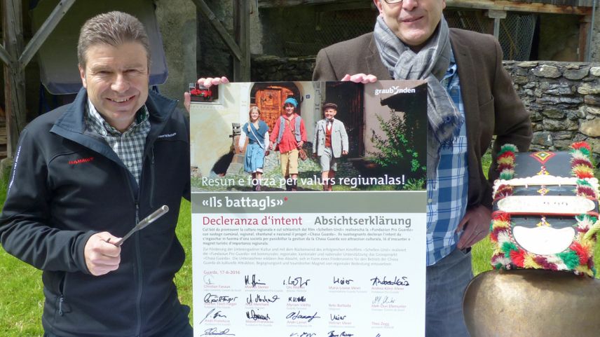 Urs Wohler (a schnestra), directer da la destinaziun turistica Engiadina Scuol Samignun Val Müstair e Markus Steiner, president da la fundaziun Pro Guarda, preschaintan la decleranza d’intent cullas prümas suottascripziuns (fotografia: Flurin Andry).