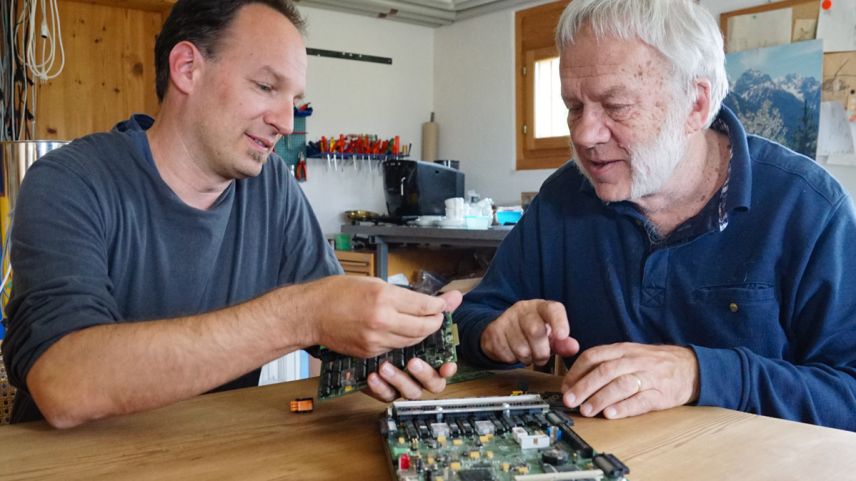 Jan e Josef Sedlacek in lur lavuratori a Sent cun duos generaziuns da lur «Swiss Industry Controller». Davantvart sün maisa la versiun extaisa dal controller A2 maxi. fotografia: Jon Duschletta