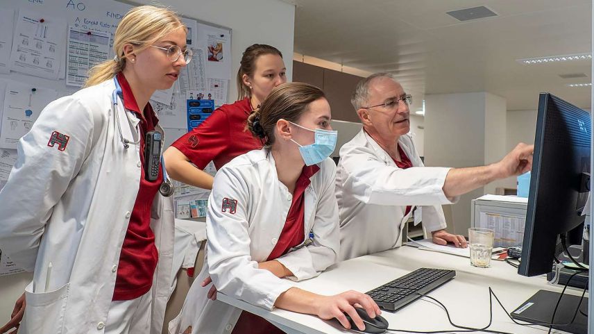 Prof. Dr. Hans-Peter Simmen bespricht mit Assistenzärztin Elina Grünert sowie den beiden Unterassistenärztinnen Nina Giudici und Stephanie Griot (von rechts) einen Fall. Foto: Reto Stifel