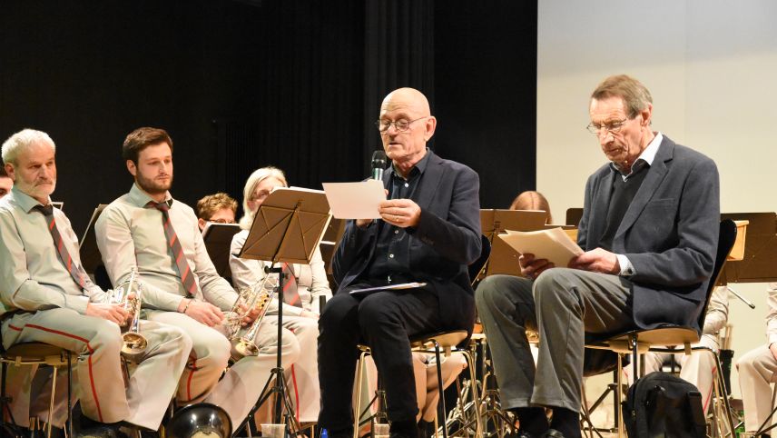 In occasiun dal concert da la Società da musica Tschlin han preschantà Duri Janett ed Erwin Salis la cronica da 150 ons (fotografia: Nicolo Bass).