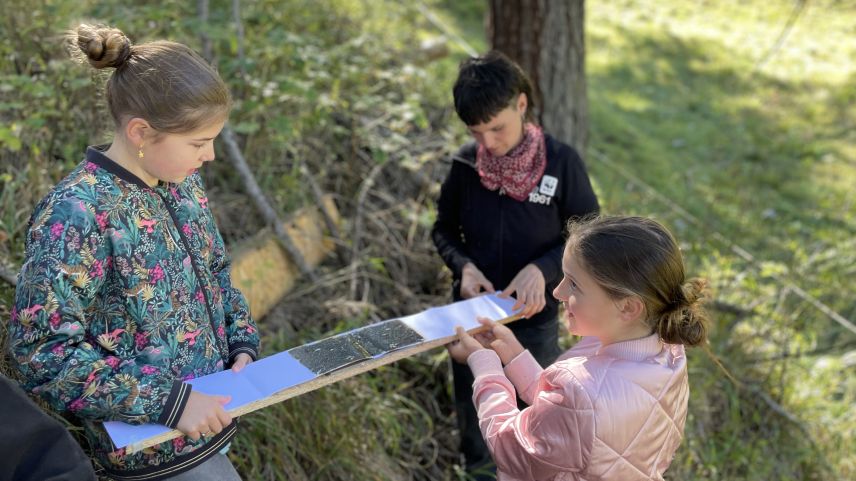 Die Kinder lernen, wie Forschende Spurentrunnels für Wiesel legen. Foto: Fadrina Hofmann