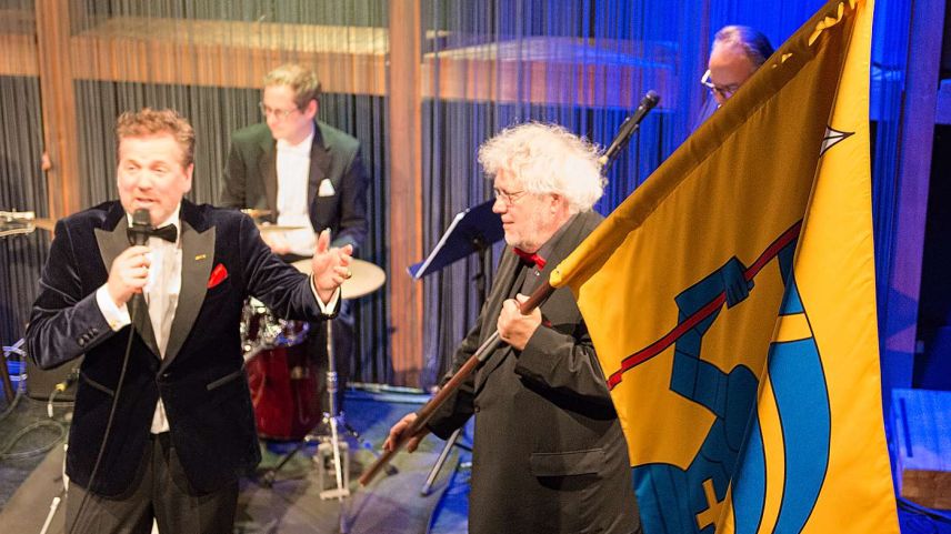 Im musikalischen Kabarettprogramm «Traktanden nach Noten – eine amtliche Revue» tritt Kapellmeister Andres Joho (rechts) auch als St. Moritzer Fähndrich auf. Fotos: Reto Stifel