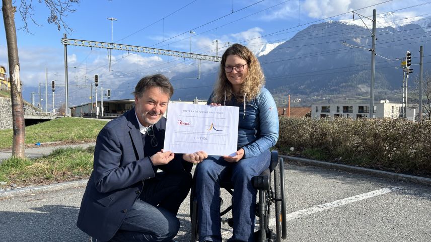 Diego Quinter, Vorstandsmitglied von «Bündner helfen Bündnern» überreicht der Präsidentin des Vereins «Inclusiun Sportiva» Marlies Zimmermann einen Scheck als Unterstützung zur Beschaffung von zwei Rollstühlen. Foto: z. Vfg