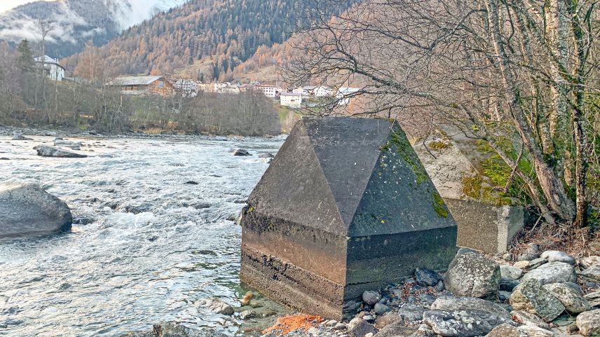 Betonhöcker der Panzersperre Planturen am Innufer. Im Hintergrund Lavin.