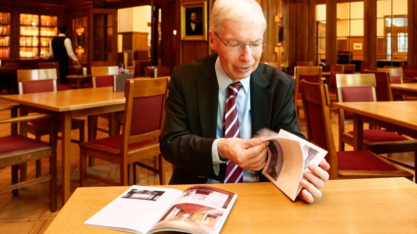 Urs Kienberger blättert in der längst vergriffenen Ausgabe des Kunstführers «Hotel Waldhaus Sils Maria» der Gesellschaft für Schweizerische Kunstgeschichte. Daneben liegt die kürzlich erschienene Neuauflage. Foto: Jon Duschletta