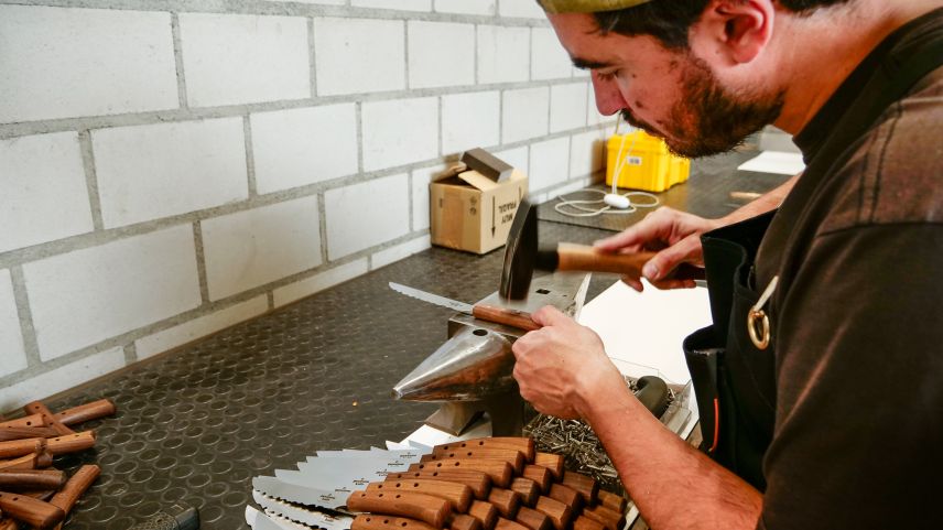 Sein Bruder Marco befestigt danach den Nussbaumgriff mit drei Stahlnieten an der Klinge, schleift diese bündig und schleift auch den Griff fertig.