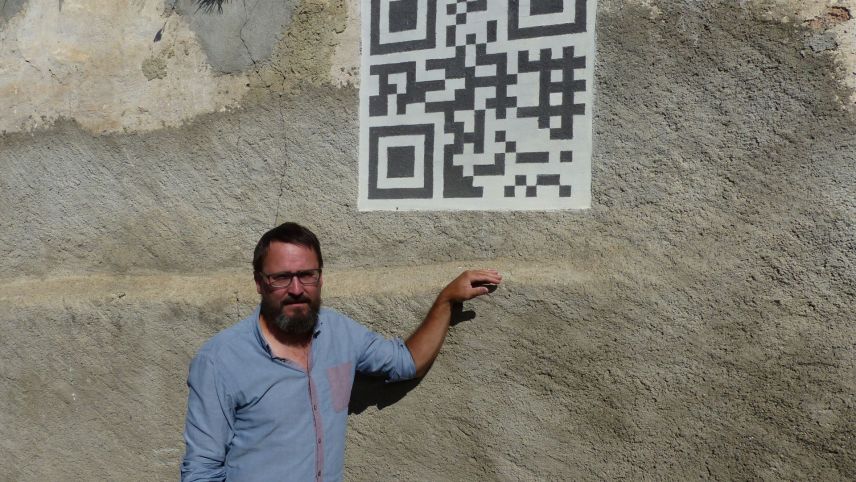 Curdin Tones davat sia chasa a Tschlin chi ha sü in fuorma da sgrafit ün QR-Code (fotografia: Flurin Andry).