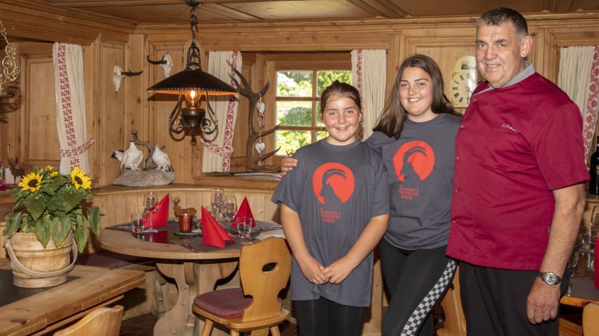 Damiano Bettini mit den beiden Töchtern Giuliana und Jessica aus zweiter Ehe im Tschuggner Gasthaus «da Damiano». 	Foto: David Henderson
