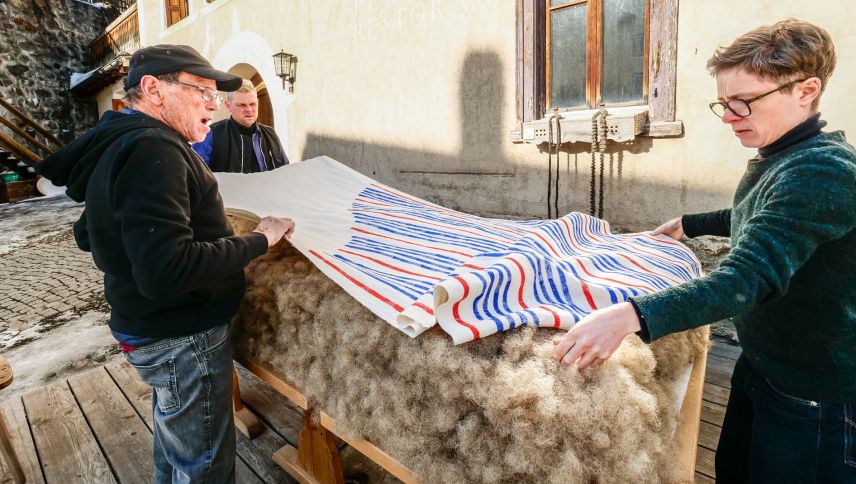 Oskar und Daniel Heer helfen Philine Rinnert die zweite Leinenbahn auf die Rosshaarfüllung zu legen. Foto: Jon Duschletta