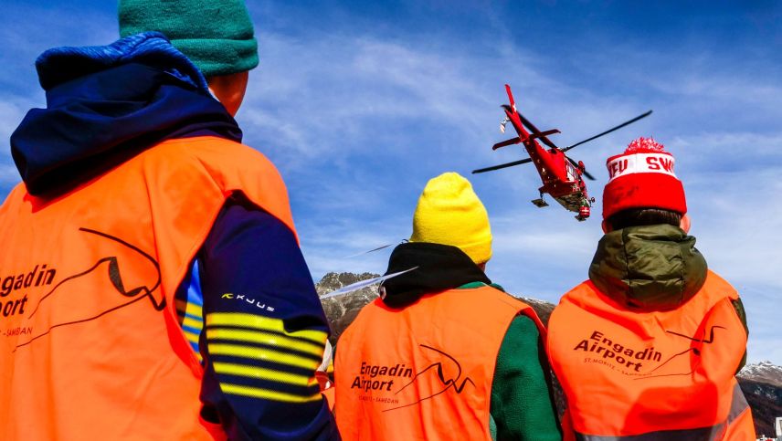 Zuschauen, wie der Rega-Helikopter von der Basis am Flughafen Samedan abhebt.