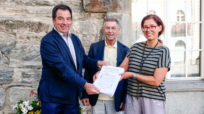 Übergabe der Flughafen-Petition am Donnerstag in Poschiavo. V.l.: Andrea Gilli nimmt die Petition mit insgesamt 1105 Unterschriften von Hansjörg Hosch und Franziska Preisig entgegen. Foto: Jon Duschletta 