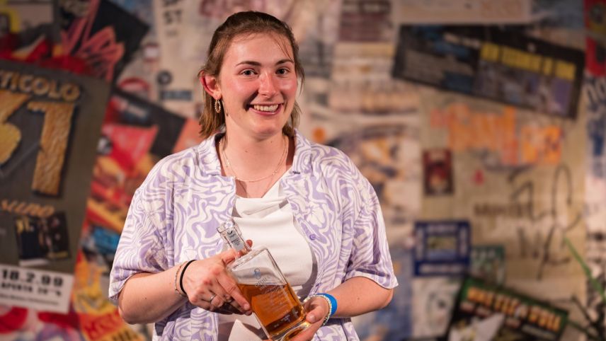 Al poetry slam rumantsch dal Festivalet, al principi da quista stà, vaiva Selina Poo da Sent surgni üna butiglia dad iva ed uschea il bigliet per rapreschantar la Rumantschia al champiunadi svizzer da poetry slam (fotografia: Gion Fry).