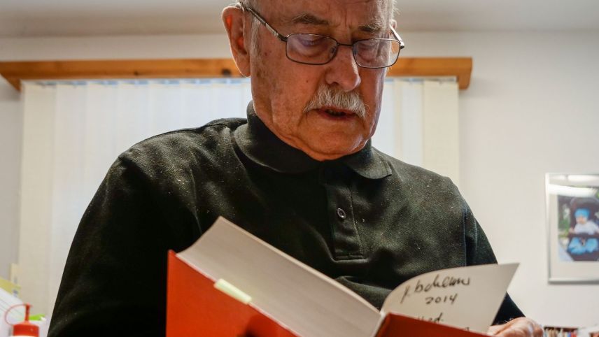 Il teolog e romanist Gion Tscharner sföglia in «seis» dicziunari puter - tudais-ch a qual el s’ha tanter oter dedichà ils ultims trais decennis. fotografia: Jon Duschletta