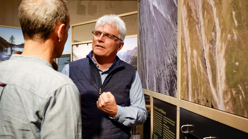 Nationalparkdirektor Ruedi Haller im Gespräch mit einem Ausstellungsbesucher.