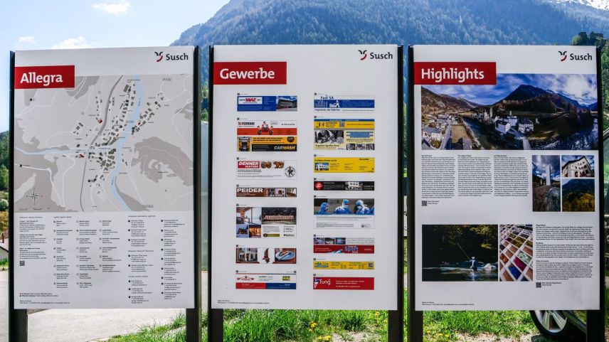Las tablas d’infuormaziun a Susch infuorman ils giasts in lingua tudais-cha, francesa ed inglaisa (fotografia: Nicolo Bass).