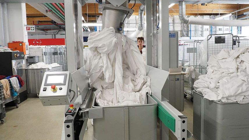 Robin zieht die gewaschene Wäsche mit einem Vakuum in die Maschine. Foto: Jan Schlatter