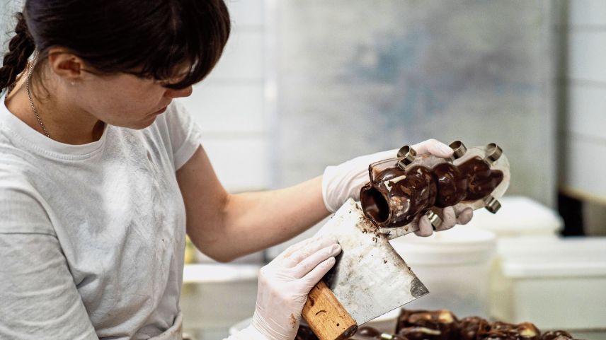Bei der Schokomasse ist die richtige Temperatur wichtig. Handarbeit beim Abfüllen und Fingerspitzengefühl beim Schminken.	Fotos: Daniel Zaugg