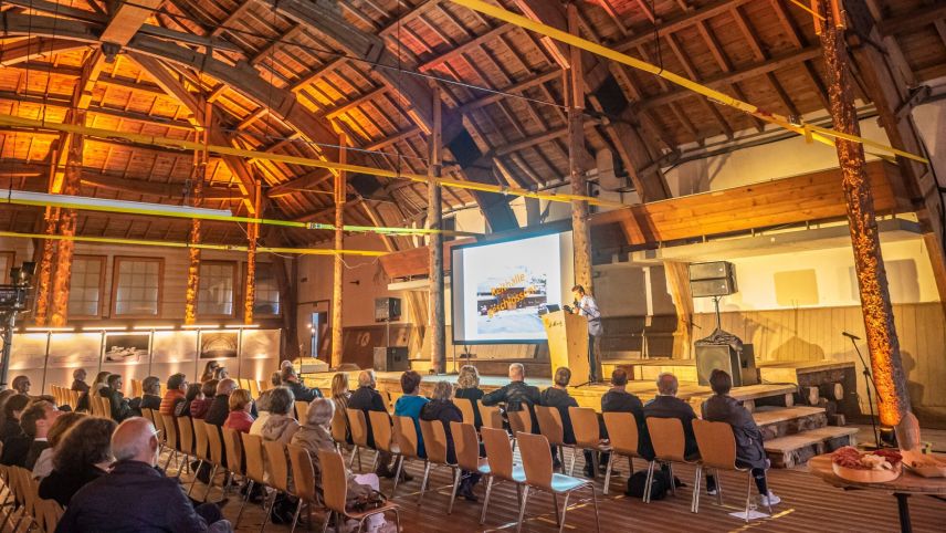 Nur gut 50 Personen wollten am Dienstagabend die Infoveranstaltung vor Ort in der Reithalle mitverfolgen. Rechts das Modell der wieder stützenfreien Reithalle nach der Sanierung. Foto: Reto Stifel, Visualisierung Gemeinde St. Moritz 