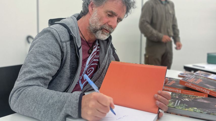Nach dem Bärenreferat signiert Reno Sommerhalder in Zernez sein neues Buch «Bärenhunger» mit Geschichten und Rezepten aus dem Alltag des Bären. Foto: Jon Duschletta