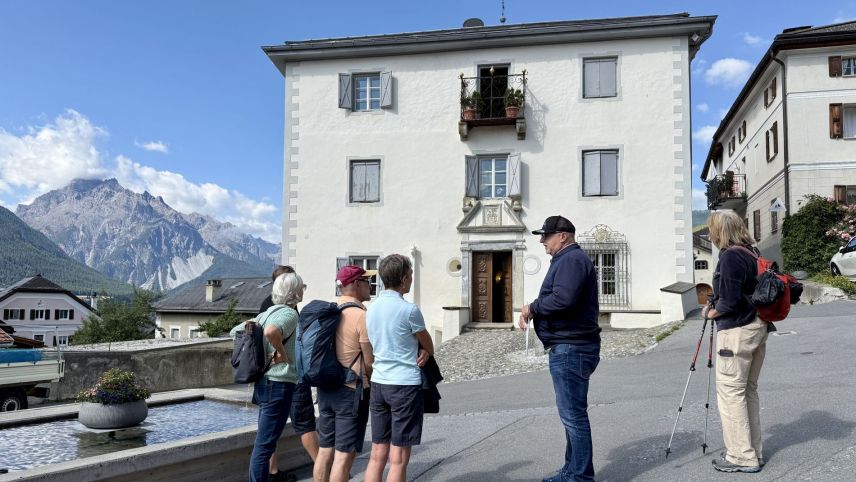 Dorfführer Domenic Bass erzählt, was es mit der Chasa dal Guvernatur auf sich hat. Foto: Fadrina Hofmann