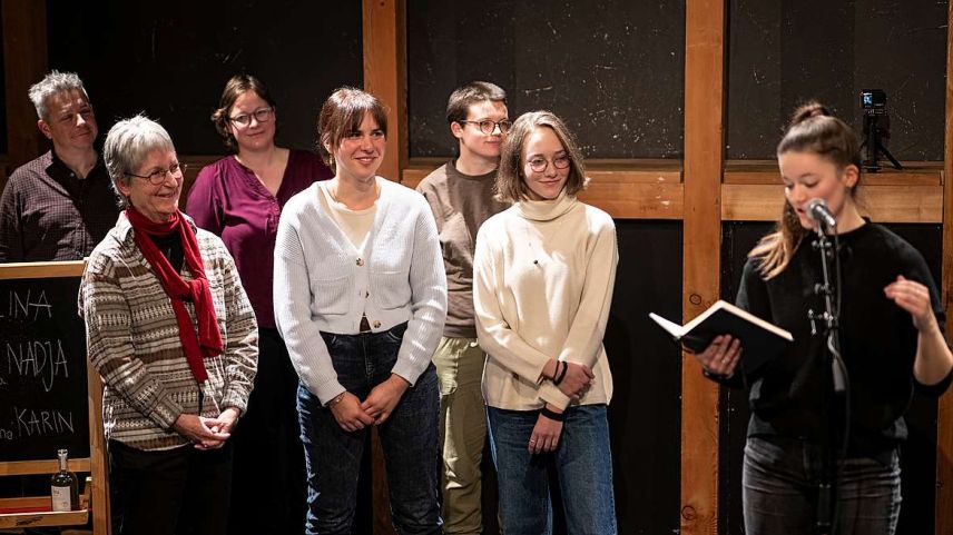 Karin Jundt (schnestra) düraunt ils Poetry Slam Engiadinais a Zuoz, chi’d es gnieu modero da Giann Duschletta (al microfon) (fotografia: Mayk Wendt).