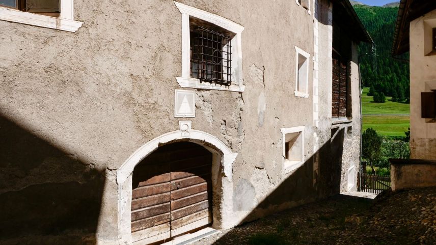 Alte Fassade mit vergittertem Fenster zur ehemaligen Vorratskammer.