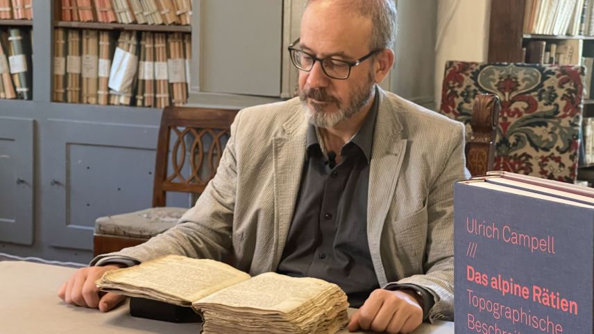 L’istoriker Florian Hitz preschainta la nouva publicaziun «Das alpine Rätien. Topographische Beschreibung von 1573 Rætiæ Alpestris topographica descriptio» (3 toms) – chi’d es cumparüda d’incuort (fotografia: Isabelle Jaeger/RTR).