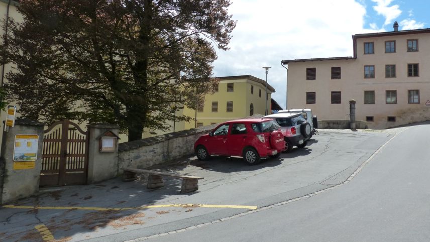 Las unicas plazzas da parcar publicas sun a Ramosch sün Plaz, sper la baselgia. Davovart as vezza chasas cun tablats tipics pel cumün (fotografia: Flurin Andry).