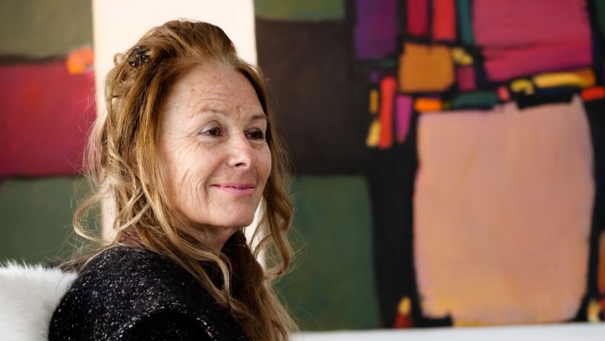 Dora Lardelli (1953-2023) hier 2021 in der Galerie La Suosta in Madulain vor einem Werk von Jacques Guidon. Foto: Jon Duschletta