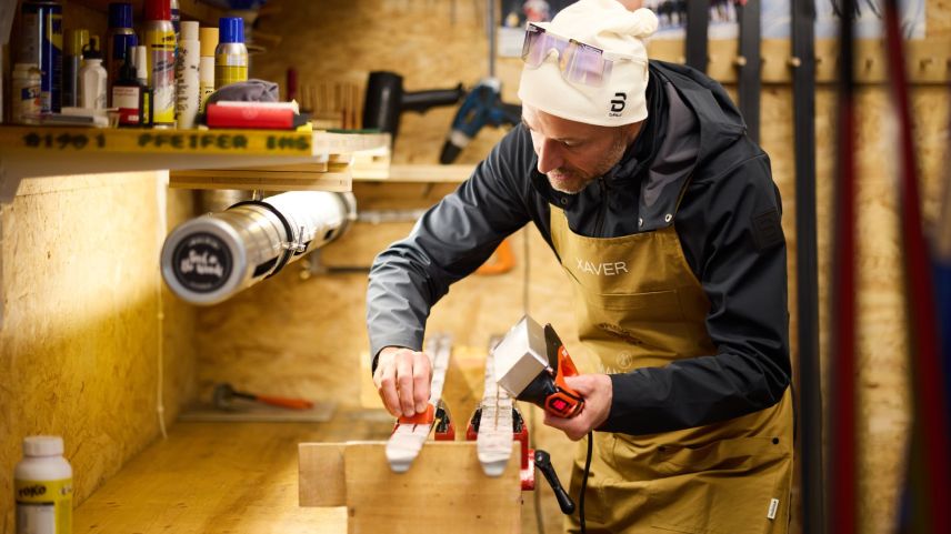 Xaver Frieser algua la tschaira sül fier da stirar e tilla stricha lura oura süls skis (fotografia: Michael Steiner).