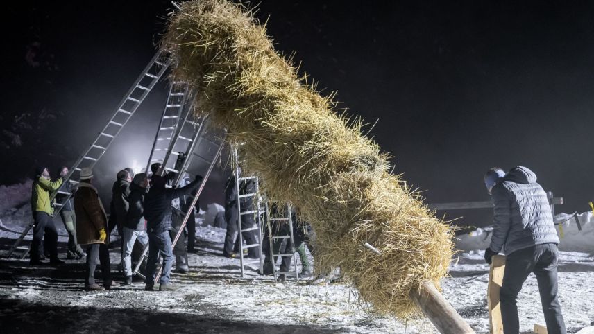 La magistraglia e'ls collavuratuors da cumün drizzan sü a l'hom strom. fotografia: Dominik Täuber