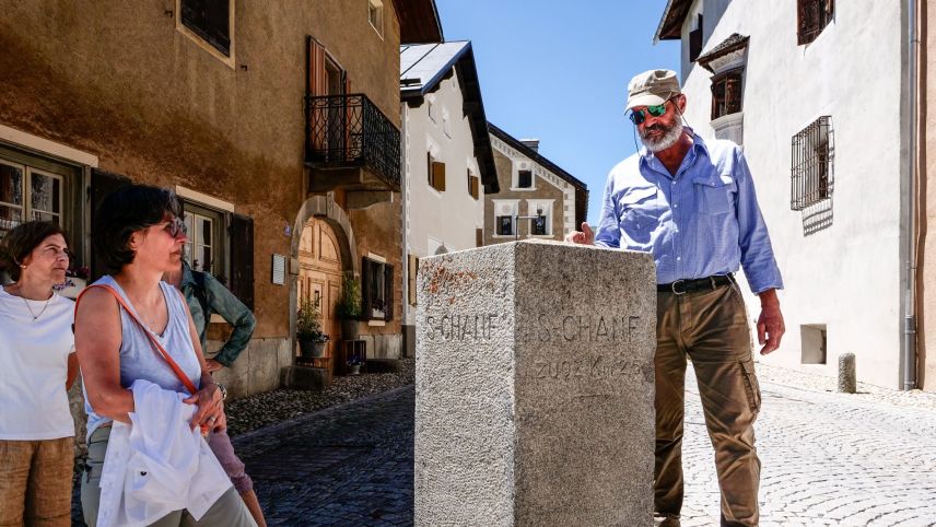 Dorfführer Ernst Parli bei einer Wegmarke mitten in S-chanf. 