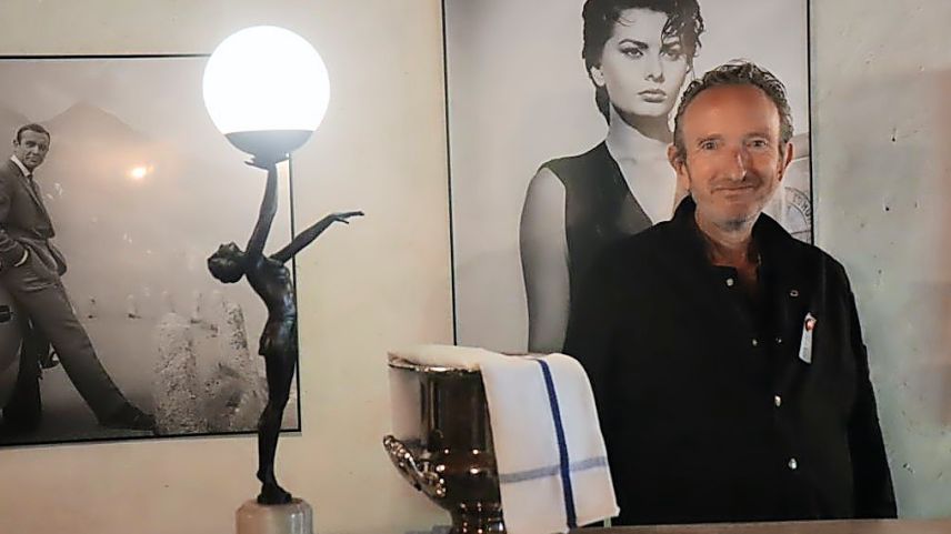 Ramun Schweizer, il possessur ed hotelier da la Chasa de Capol a Sta. Maria davant la bar da kino (fotografia: Martin Camichel).