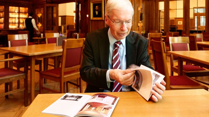 Urs Kienberger blättert in der längst vergriffenen Ausgabe des Kunstführers «Hotel Waldhaus Sils Maria» der Gesellschaft für Schweizerische Kunstgeschichte. Daneben liegt die kürzlich erschienene Neuauflage. Foto: Jon Duschletta