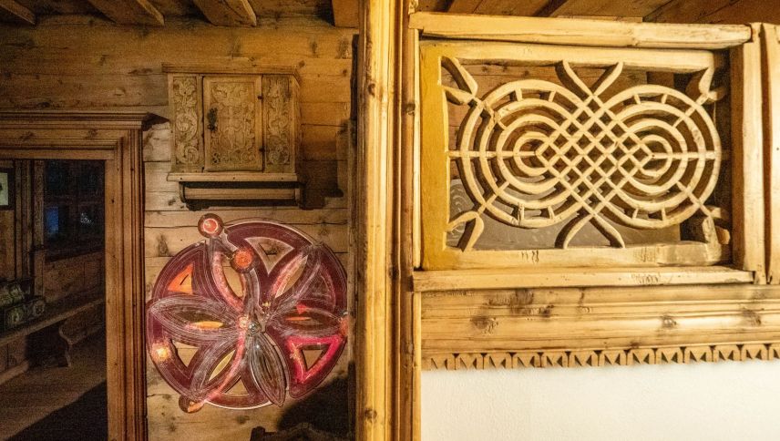 Rosetten, neue und museale, interagieren im Museum mit Ästen und Astlöchern und "beobachten" und "lenken" Besucherinnen und Besucher. Foto: Jon Duschletta