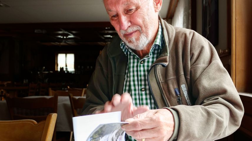 Fritz Felix sföglia i’l cudesch sur dals cumüns concessiunaris, ch’el ha scrit ed edi dal 2024 sün basa da material d’archiv. fotografias: Jon Duschletta