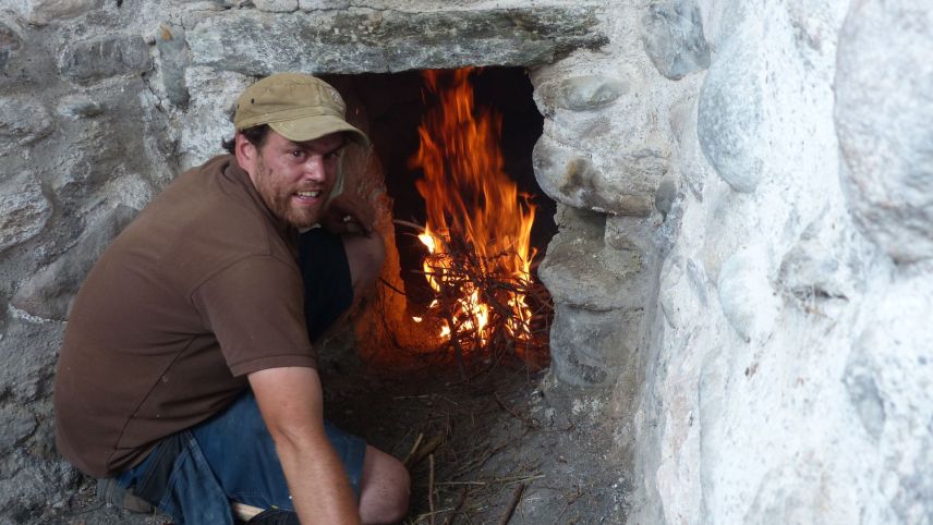 Joannes Wetzel impizza eir quista stà darcheu il fö illa chalchera «Stella» a Sur En (fotografia: Flurin Andry).