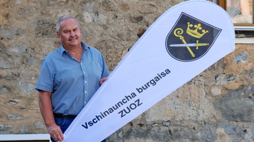 Il president da la Vschinauncha burgaisa da Zuoz, Gian Rudolf Caprez, davaunt la Chesa Tuor Purtun our dal temp
medievel, cun la bindera nouva. fotografia: Jon Duschletta