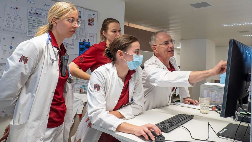 Prof. Dr. Hans-Peter Simmen bespricht mit Assistenzärztin Elina Grünert sowie den beiden Unterassistenärztinnen Nina Giudici und Stephanie Griot (von rechts) einen Fall. Foto: Reto Stifel