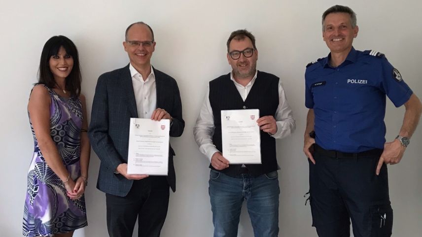 Die stellvertretende Gemeindeschreiberin Emilia Tosio, Gemeindepräsident Giovanni Jochum, Regierungsrat Peter Peyer und Polizeikommandant Walter Schlegel anlässlich der Vertragsunterzeichnung. Foto: Kantonspolizei Graubünden