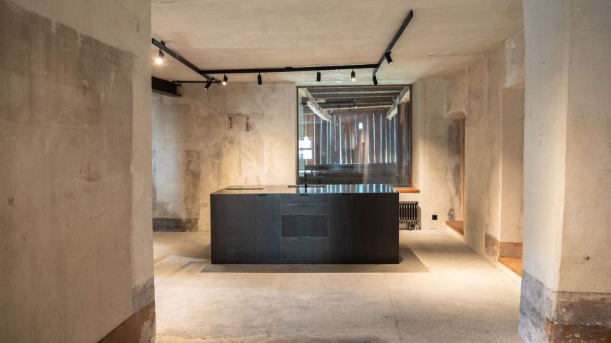 Grosse, auf den ursprünglichen Zustand zurückversetzte Räume mit moderner Einbaute und Sicht in den kathedralähnlichen Heustall. 