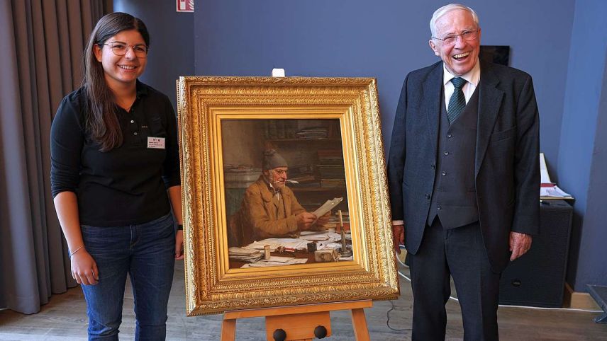 Vorstandsmitglied Egzona Zyberaj und Christoph Blocher posieren mit «Der Gemeindeschreiber» von Albert Anker Foto: slushhill