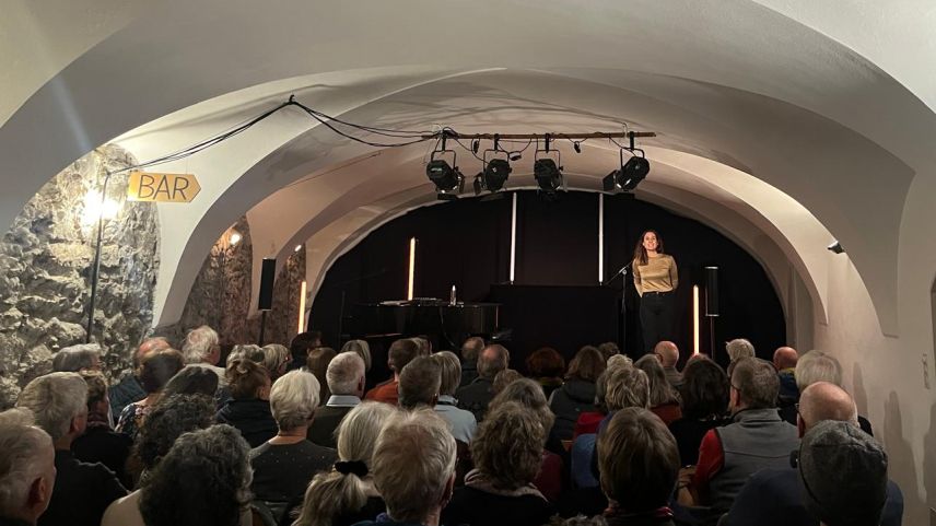 Anna Serarda Campell, la presidenta da la suprastanza, sül palc da La Vouta. Ils vouts caracteristics dal local han dat il nom al lö da cultura a Lavin (fotografia: mad).