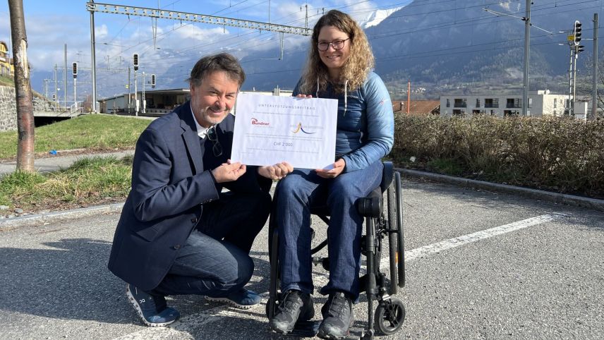 Diego Quinter, Vorstandsmitglied von «Bündner helfen Bündnern» überreicht der Präsidentin des Vereins «Inclusiun Sportiva» Marlies Zimmermann einen Scheck als Unterstützung zur Beschaffung von zwei Rollstühlen. Foto: z. Vfg