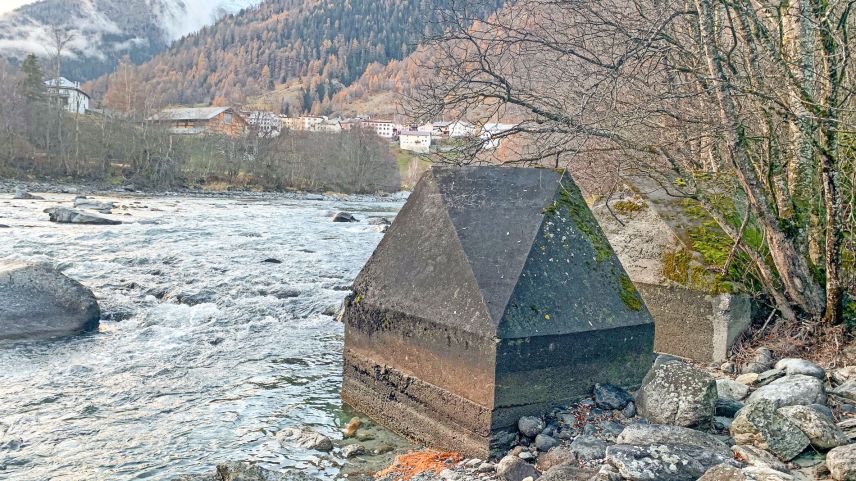 Betonhöcker der Panzersperre Planturen am Innufer. Im Hintergrund Lavin.
